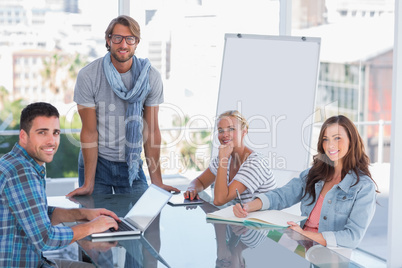 Team having meeting and smiling at camera