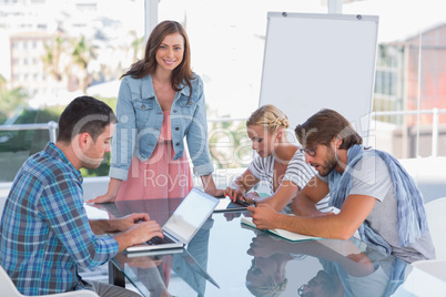 Team having meeting with one woman smiling at camera