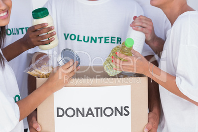 Volunteers putting food in donation box