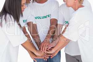 Happy volunteers putting hands together