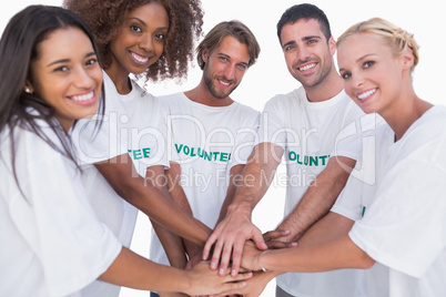 Smiling volunteer group putting hands together
