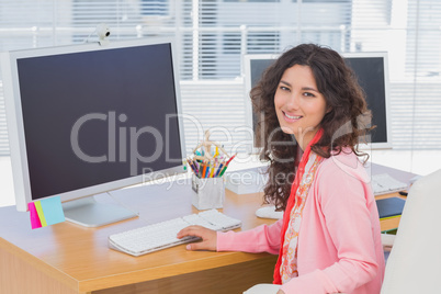 Woman working in a creative office and smiling at camera