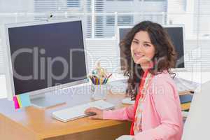 Woman working in a creative office and smiling at camera