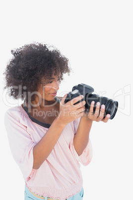 Smiling woman looking through digital camera Smiling woman looking through digital camera