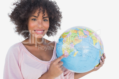 Happy woman pointing to globe