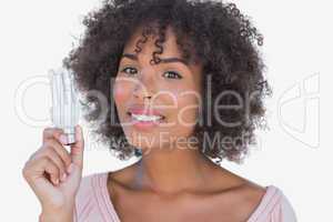 Happy woman holding energy saving light bulb