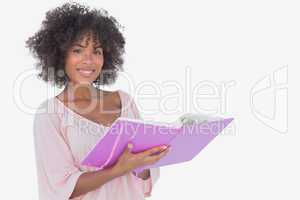 Beautiful woman holding photo album and smiling at camera
