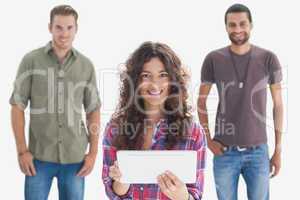 Stylish friends smiling at camera with one holding tablet