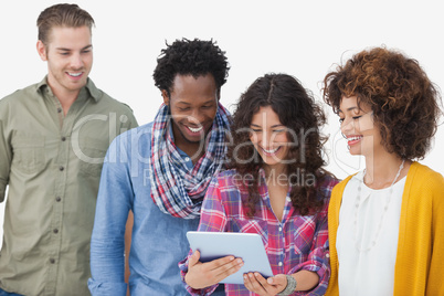 Four stylish friends looking at tablet