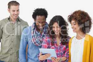 Four stylish friends looking at tablet