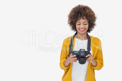 Woman looking at her digital camera and smiling