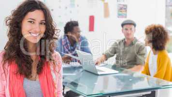 Smiling woman with creative team working behind