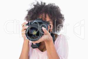 Woman with afro wearing pink top taking a photo