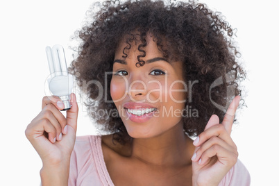 Woman holding light bulb and pointing up