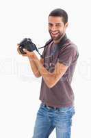 Stylish man holding camera and smiling