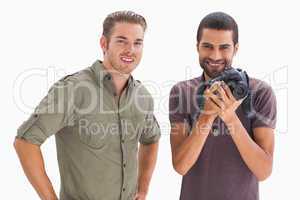 Stylish friends smiling with one holding camera