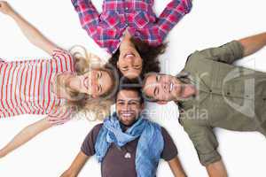 Friends lying in a circle and smiling at camera