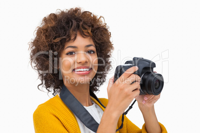 Smiling girl taking a photo and looking at camera