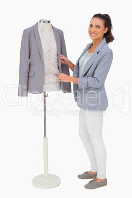 Fashion designer fixing blazer on mannequin