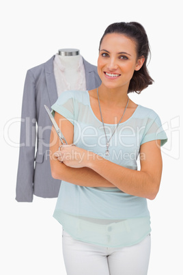 Designer holding scissors in front of mannequin