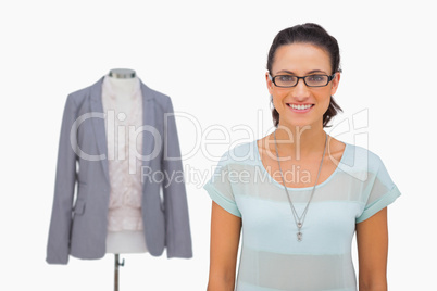 Designer smiling at camera with mannequin behind
