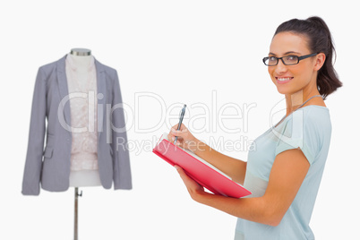 Happy designer looking at camera and taking notes Happy designer looking at camera and taking notes