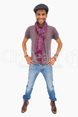 Happy man wearing peaked cap and scarf looking at camera
