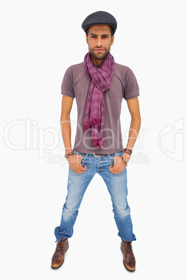 Serious man wearing peaked cap and scarf looking at camera