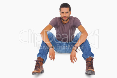 Handsome man sitting on floor