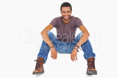 Handsome man sitting on floor and smiling