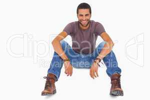 Handsome man sitting on floor and smiling