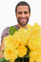 Handsome man offering bunch of yellow roses