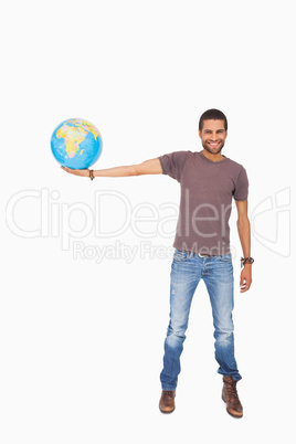 Handsome man holding out a globe