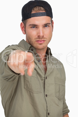 Man wearing baseball hat backwards and pointing