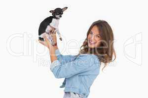 Smiling woman lifting her chihuahua