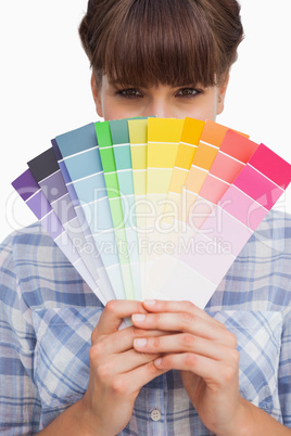 Pretty girl hiding face with colour charts