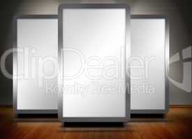 Three blank screens standing on wooden floor
