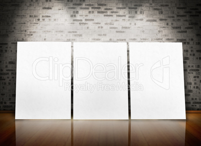 Three posters standing in line in a parquet floor like an art ex
