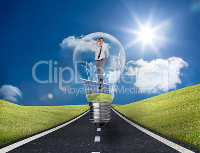Businessman in light bulb with wind turbines and solar panels