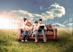 Happy family using the laptop in a field
