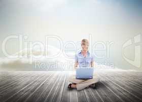 Cute blonde woman using laptop over wooden boards