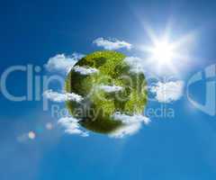 Green planet floating bright blue sky