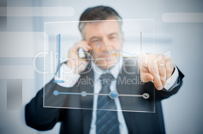 Businessman using futuristic touchscreen to view graph