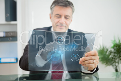 Businessman using futuristic touchscreen to view statistics