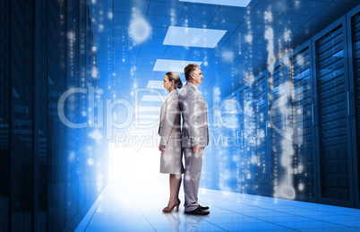 Business people standing back to back in data center