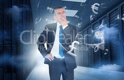 Businessman standing in data center with currency graphics