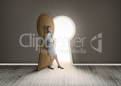 Businesswoman leaning against keyhole shaped doorway