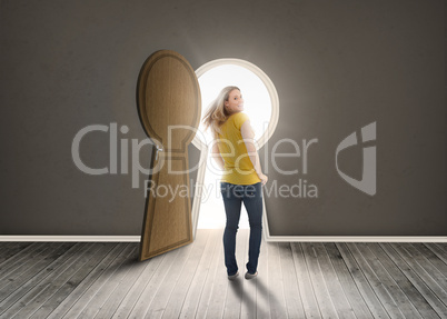 Woman walking towards keyhole shaped doorway with light