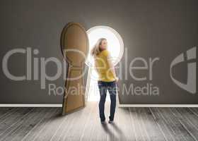 Woman walking towards keyhole shaped doorway with light