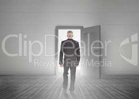 Businessman walking towards door showing light